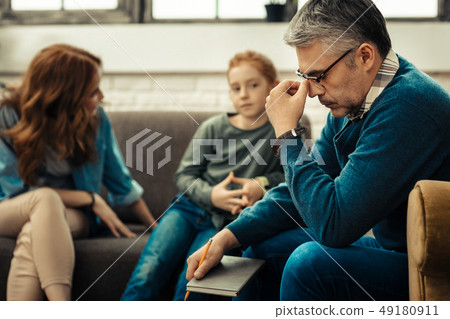 Cheerless mature man holding his bridge of the nose 49180911