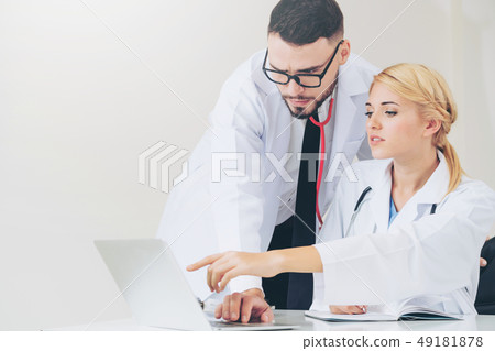 Doctor at hospital works on computer with partner. 49181878