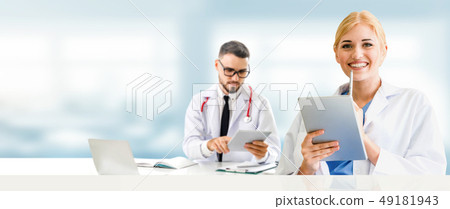 Doctor at hospital works on computer with partner. Doctor at hospital works on computer with partner. 49181943