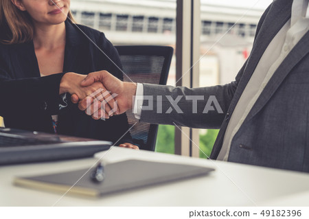Businessman handshake businesswoman in office. Businessman handshake businesswoman in office. 49182396