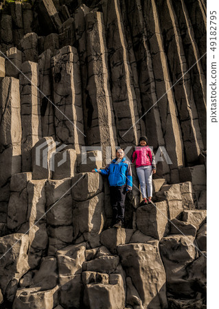Traveler on hexagonal rocks in Vik, Iceland. 49182795