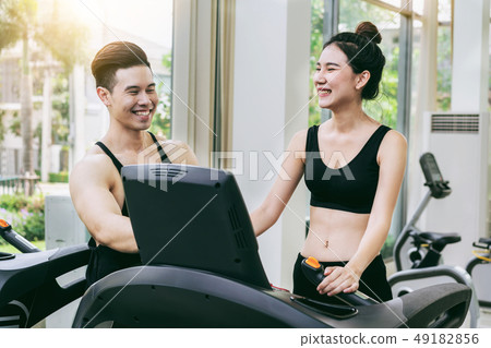 Sporty runner running on treadmill in fitness gym. 49182856