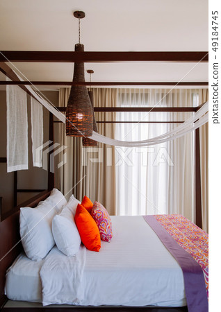 Asian tropical hotel room with four poster bed 49184745
