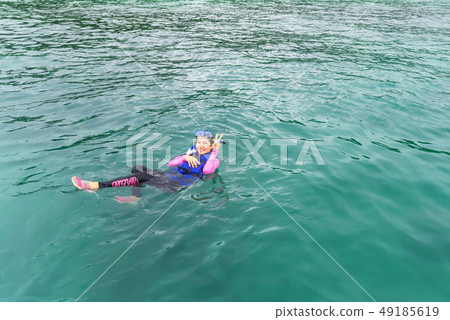 Happy women is posing in blue water with fishes 49185619