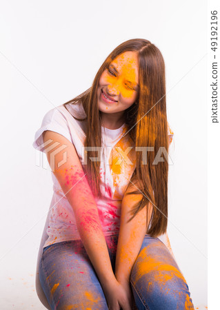 Festival of holi, holidays and people concept - young woman dirty, smiling to the camera on white Festival of holi, holidays and people concept - young woman dirty, smiling to the camera on white 49192196