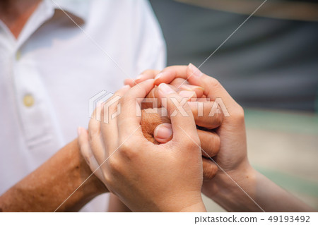 Asian senior and asian young holding hands. 49193492