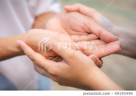 Asian senior and asian young holding hands. 49193494