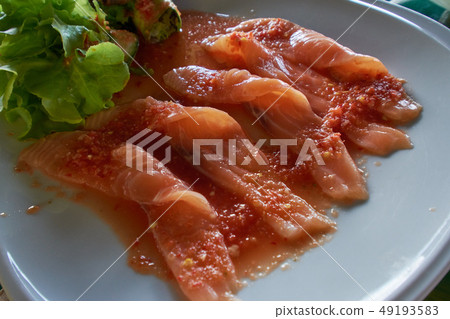 strip raw salmon in spicy sauce salad 49193583