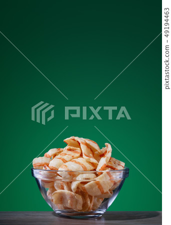 Plate with chips and bacon on green background Plate with chips and bacon on green background 49194463