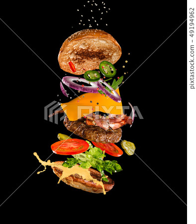 Tasty hamburger with flying ingredients on dark background 49194962