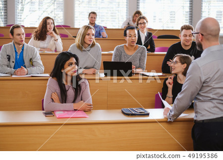 Lecturer and multinational group of students in an auditorium 49195386
