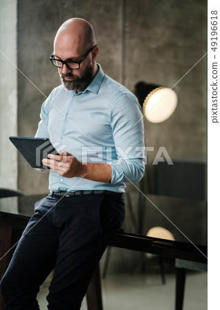 Middle-aged man with a tablet pc in an office Middle-aged man with a tablet pc in an office 49196618