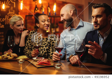 Group of friends having fun talk behind bar counter in a cafe Group of friends having fun talk behind bar counter in a cafe 49196952