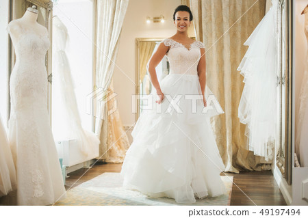 Beautifu bride choosing wedding dress in a wedding salon Beautifu bride choosing wedding dress in a wedding salon 49197494