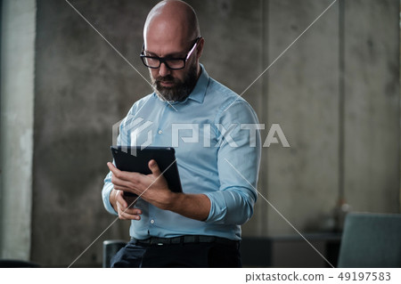 Middle-aged man with a tablet pc in an office 49197583