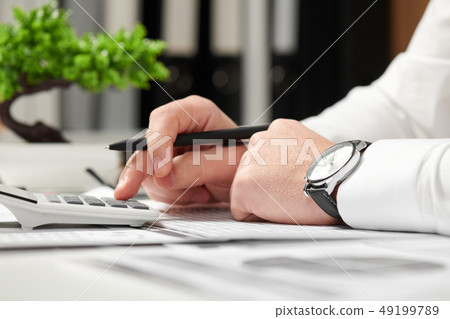 Businessman working in office and calculating Businessman working in office and calculating 49199789