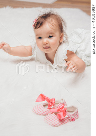 Newborn baby and a pair of baby shoes Newborn baby and a pair of baby shoes 49199987