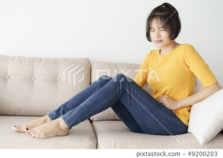 Young asian woman sit on sofa in the living room. Young asian woman sit on sofa in the living room. 49200203