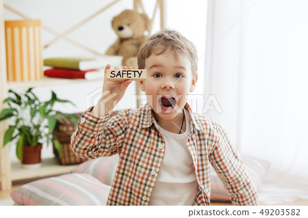 Wooden cubes with word safety in hands of little boy 49203582
