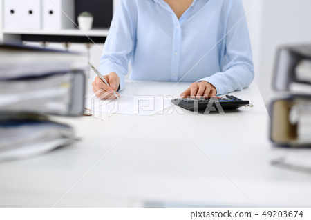 Binders with papers are waiting to be processed by business woman or bookkeeper back in blur Binders with papers are waiting to be processed by business woman or bookkeeper back in blur 49203674