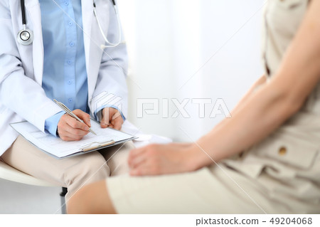 Doctor and patient talking. Physician at work in hospital while writing up medication history 49204068