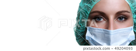 Female doctor face wearing protective mask and green surgeon cap 49204093