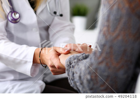 Friendly female doctor hold patient hand in office during reception 49204118