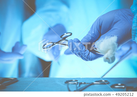 Surgeons hands holding surgical scissors and passing surgical equipment, close-up. Health care and Surgeons hands holding surgical scissors and passing surgical equipment, close-up. Health care and 49205212