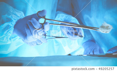 Surgeons hands holding surgical scissors and passing surgical equipment, close-up. Health care and Surgeons hands holding surgical scissors and passing surgical equipment, close-up. Health care and 49205257