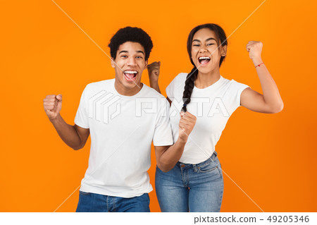 Lucky teens raising their hands in happy amazement Lucky teens raising their hands in happy amazement 49205346