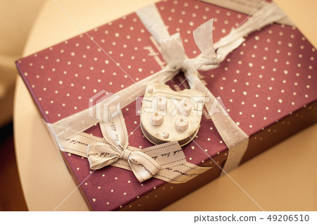 red Present box with decorative castle on table 49206510
