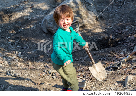 Toddler boy digging with a shovel Toddler boy digging with a shovel 49206833