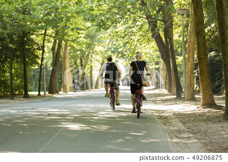 Man & woman biking in the Amsterdam Vondelpark Man & woman biking in the Amsterdam Vondelpark 49206875