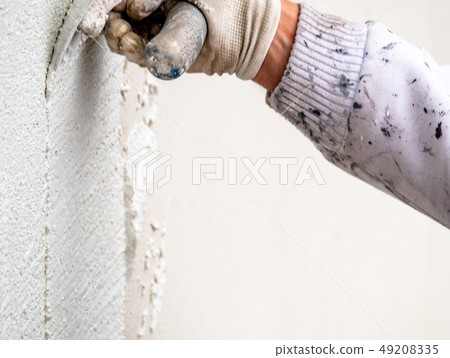 Construction worker plastering and smoothing concrete wall with cement Construction worker plastering and smoothing concrete wall with cement 49208335