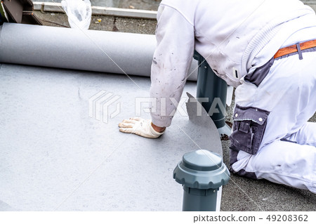 Construction worker using tarpaulin as covering sheet to protect the ground Construction worker using tarpaulin as covering sheet to protect the ground 49208362