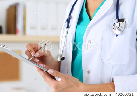 Female medicine doctor hand holding silver pen Female medicine doctor hand holding silver pen 49209321
