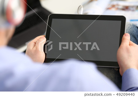 Male arms with pc pad wired to headphones at home 49209440