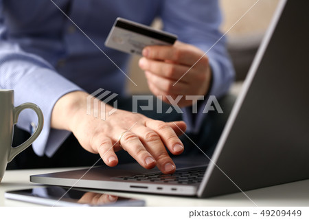 Male arms hold credit card press buttons making transfer Male arms hold credit card press buttons making transfer 49209449