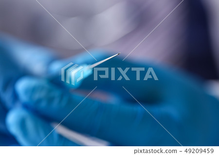 Physician arms wearing protective blue gloves prepare syringe Physician arms wearing protective blue gloves prepare syringe 49209459