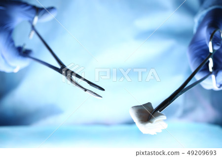 Surgeons hands holding surgical instrument 49209693