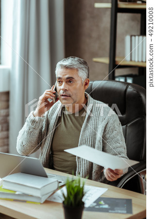 Pleasant good looking man talking on the phone 49210008