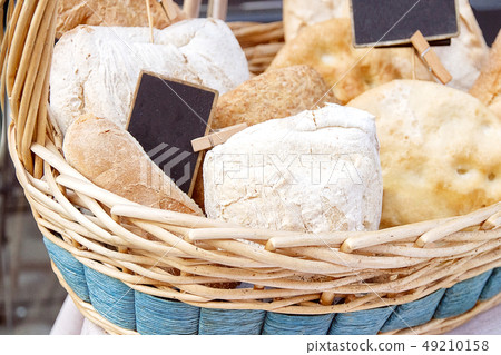 fresh bread, baguette in a wicker basket on italy street fresh bread, baguette in a wicker basket on italy street 49210158