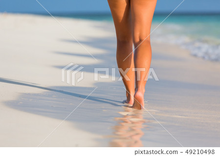 Woman legs walking on the beach Woman legs walking on the beach 49210498