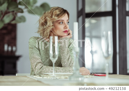 Wife waiting for husband sitting at the table with empty glasses 49212138