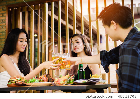 Teeneger asian friends clinking glasses while Teeneger asian friends clinking glasses while 49213705