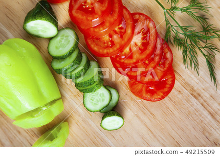 Sliced vegetables for salad on a cutting board. Sliced vegetables for salad on a cutting board. 49215509