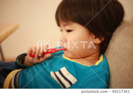 Boy brushing tooth 49217361