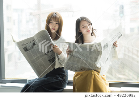 讀報紙的兩名婦女在窗口邊 49220982