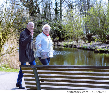 Two seniors seniors walking in spring park 49226755