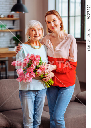 Full-length shot grey-haired dame posing with lady in pinkish blouse 49227373